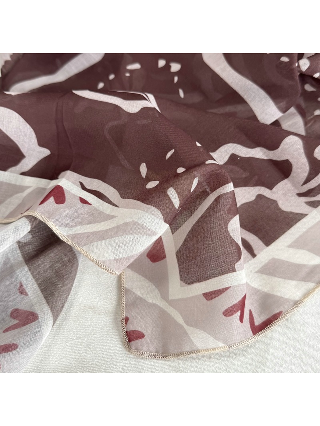 Close-up of the Coffee Faces pattern and light-colored stitched edge