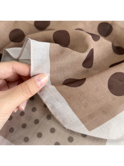 Close-up of the Beige Dots scarf border, sheer surface and stitched edge