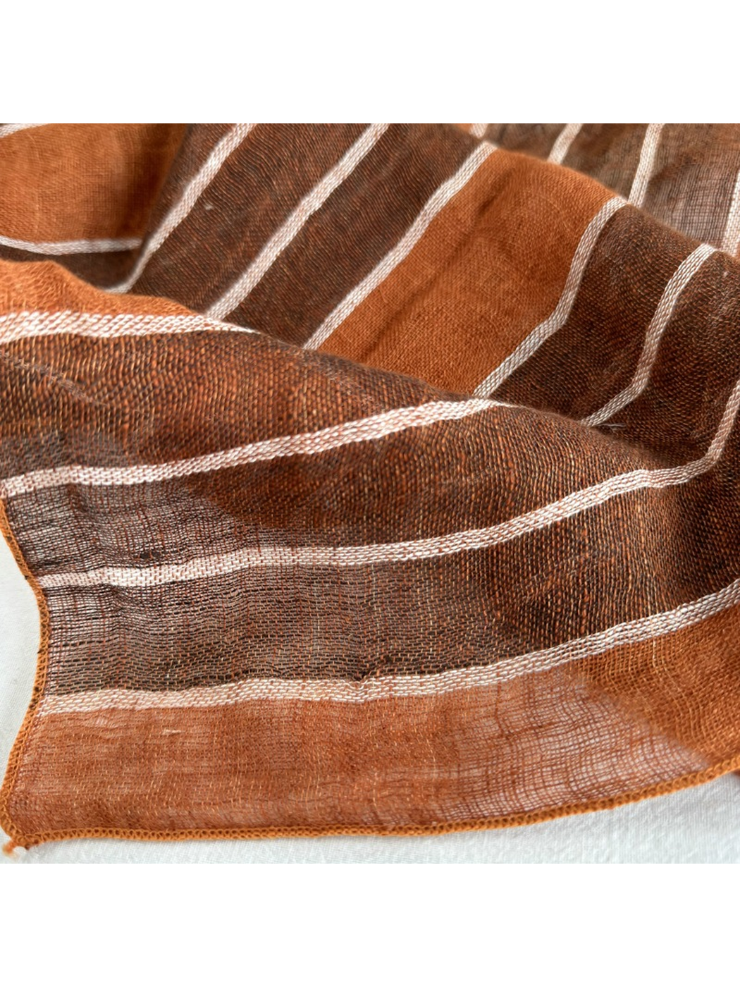 Close-up of the Rust Stripe scarf showing its striped weave and finished edge