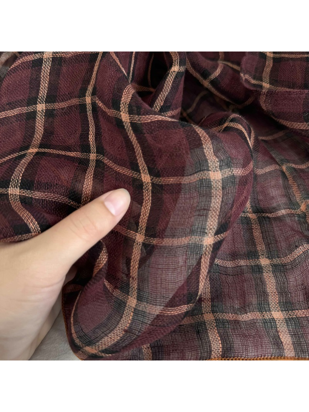 Close-up of the Burgundy Plaid scarf pattern and sheer woven texture