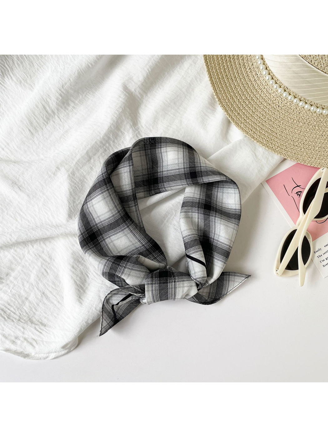 Black Gray plaid square scarf tied beside a sun hat and sunglasses