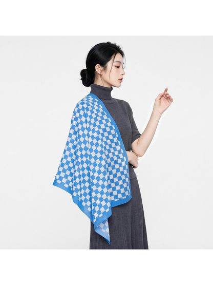 Checkerboard scarf draped over the shoulder with a gray outfit