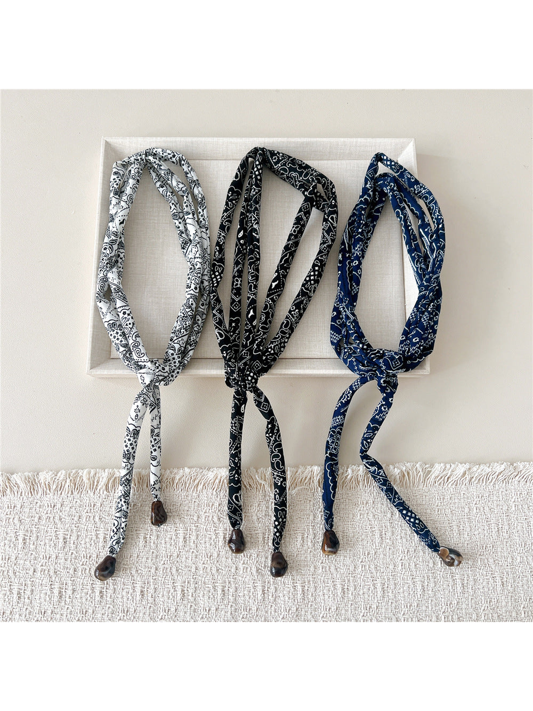 White, Black and Navy paisley skinny scarves displayed together