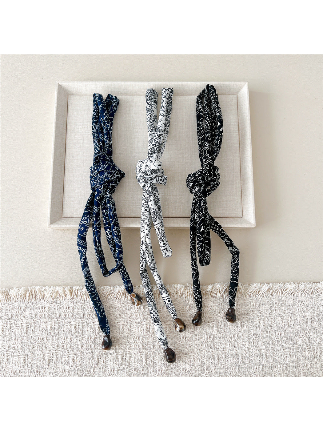 Navy, White and Black paisley skinny scarves tied in compact knots