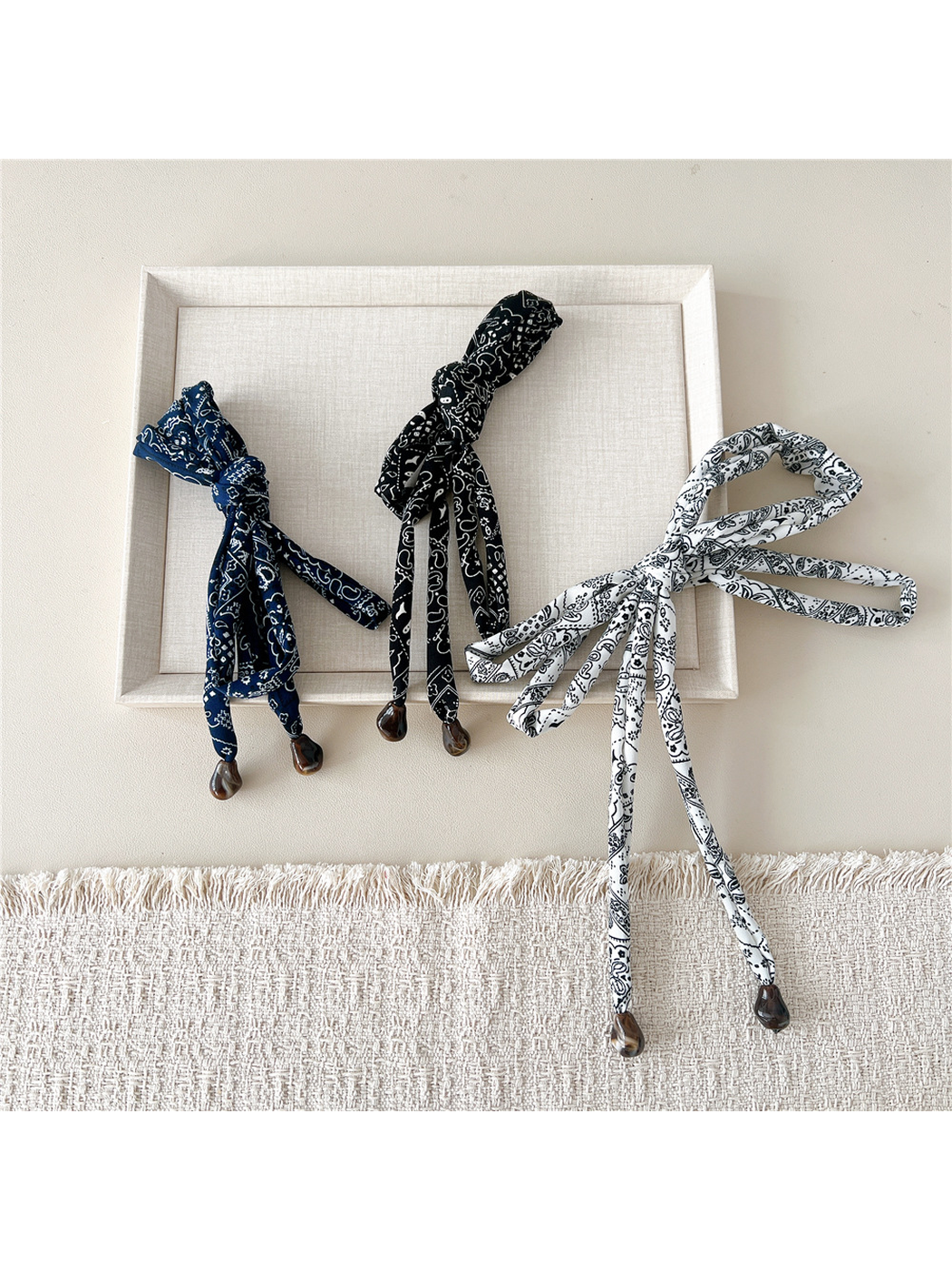 Navy, Black and White paisley skinny scarves arranged in decorative bows