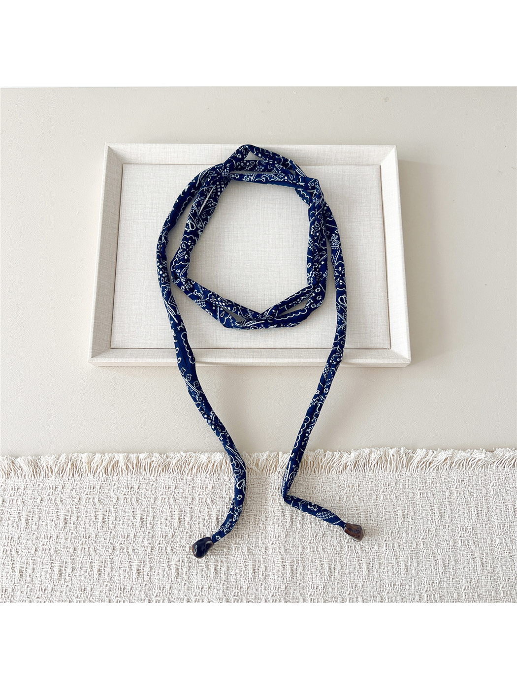Navy paisley skinny scarf loosely wrapped with long ends
