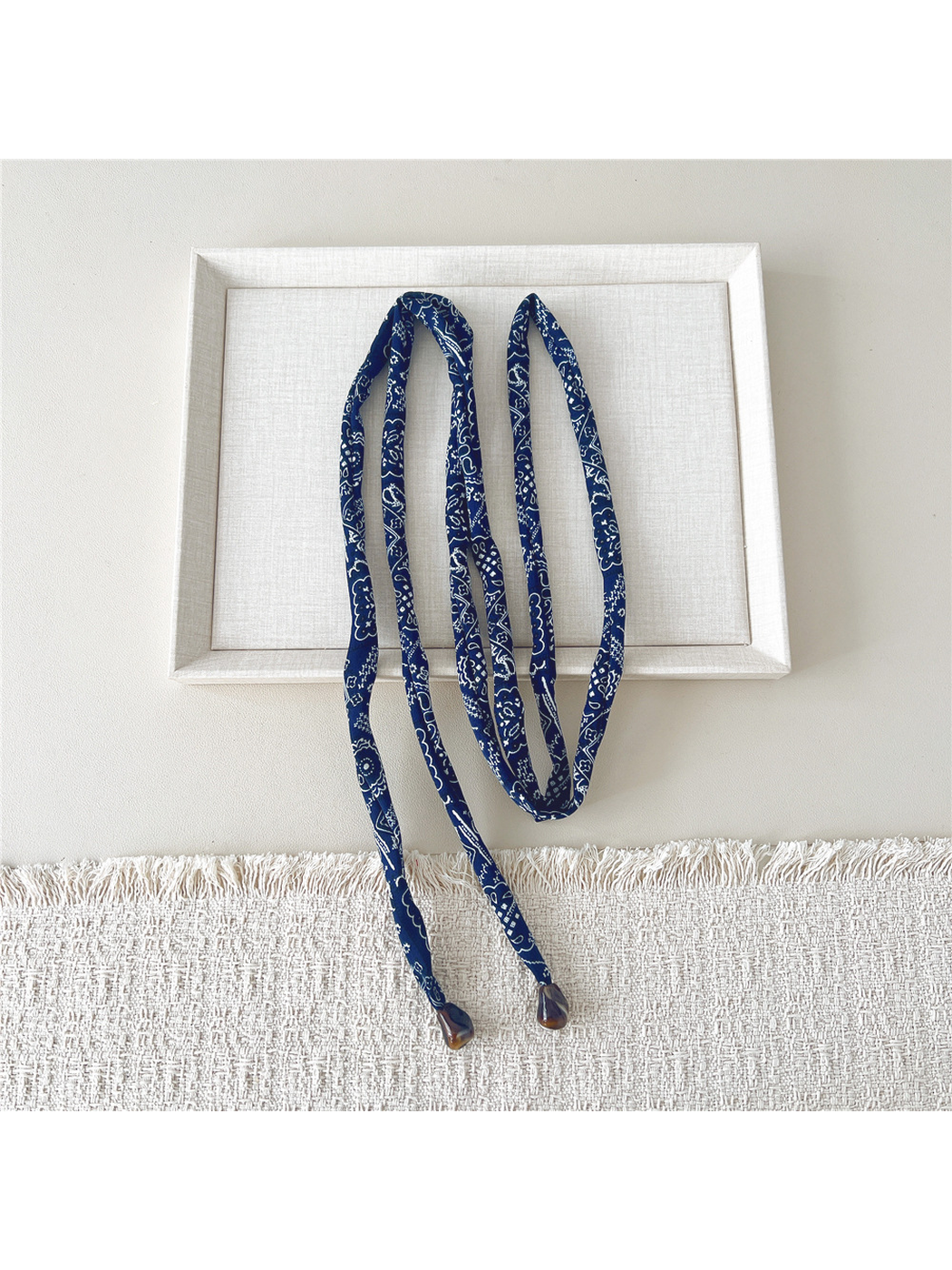 Navy paisley skinny scarf extended to show its long narrow shape