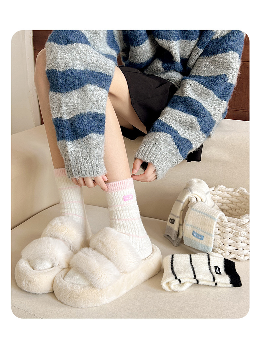 Pink striped crew socks worn with cream fuzzy slippers and other colors nearby