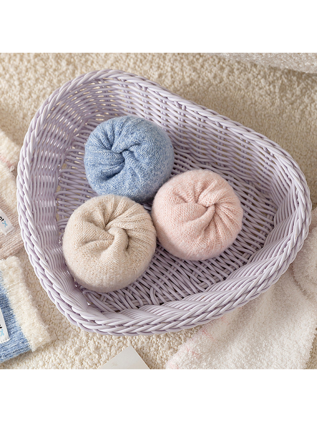 Rolled Beige, Light Blue, and Light Pink ribbed socks in a basket