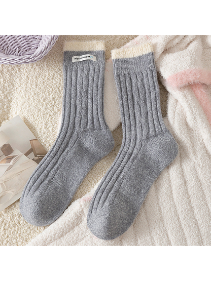 Gray ribbed crew socks with contrasting fuzzy cuffs, flat lay