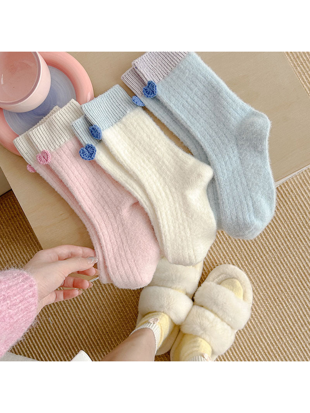 Ivory, Light Pink and Light Blue crew socks arranged in a casual indoor setting