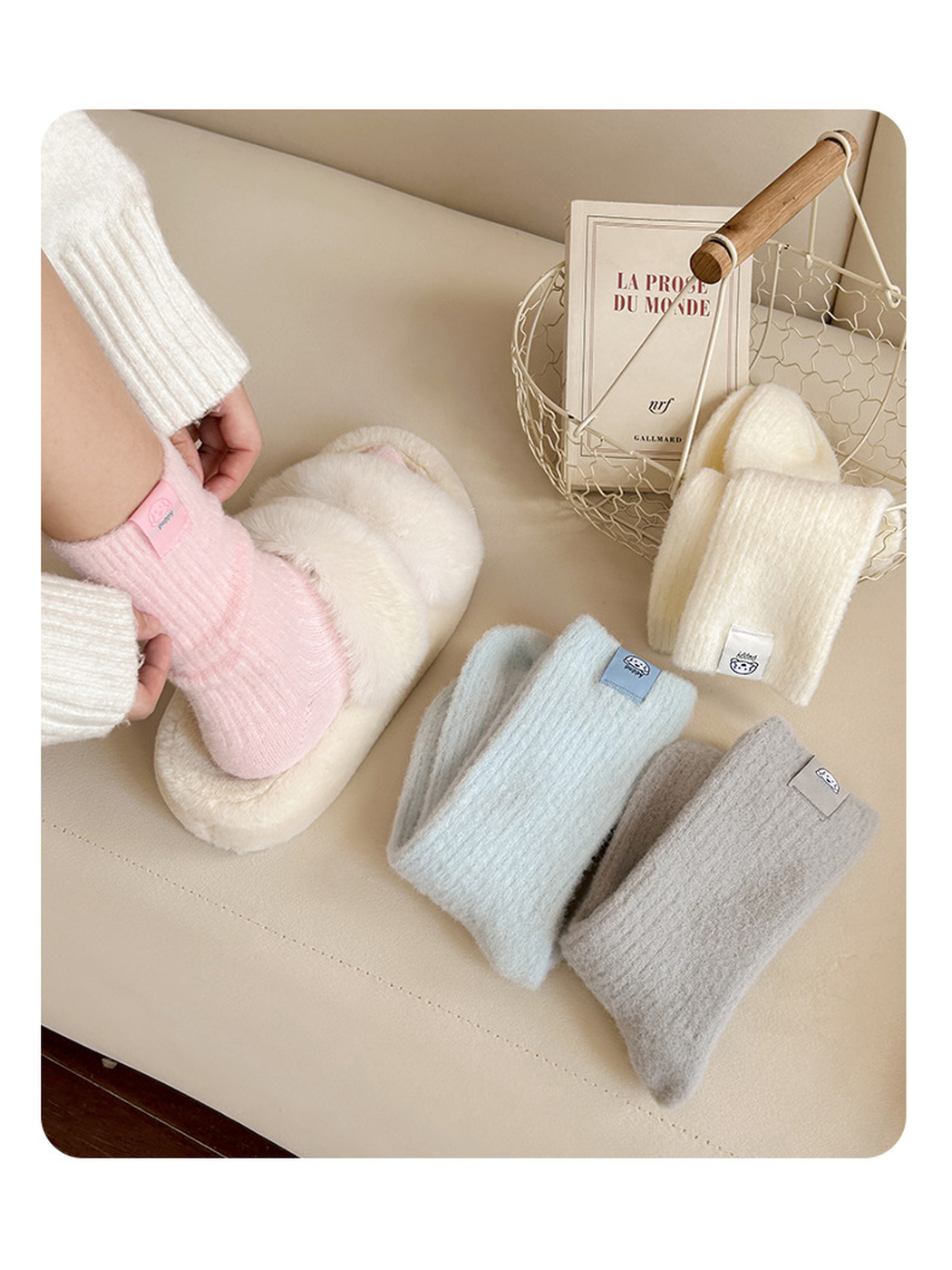 Light Pink ribbed crew sock worn with a slipper beside folded Ivory, Light Blue, and Light Gray colors