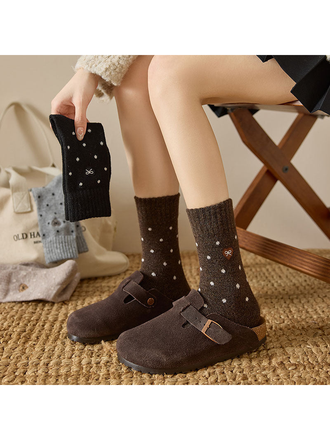 Dark Brown dot-pattern crew socks worn with Black socks held beside them