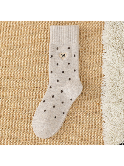 Beige dot-pattern crew sock with ribbed cuff and bow patch