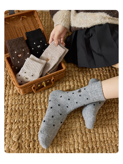 Heather Gray dot-pattern crew socks worn beside coordinating colors in a wicker case