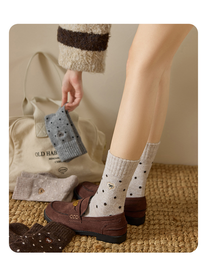 Beige dot-pattern crew socks worn with loafers, side view