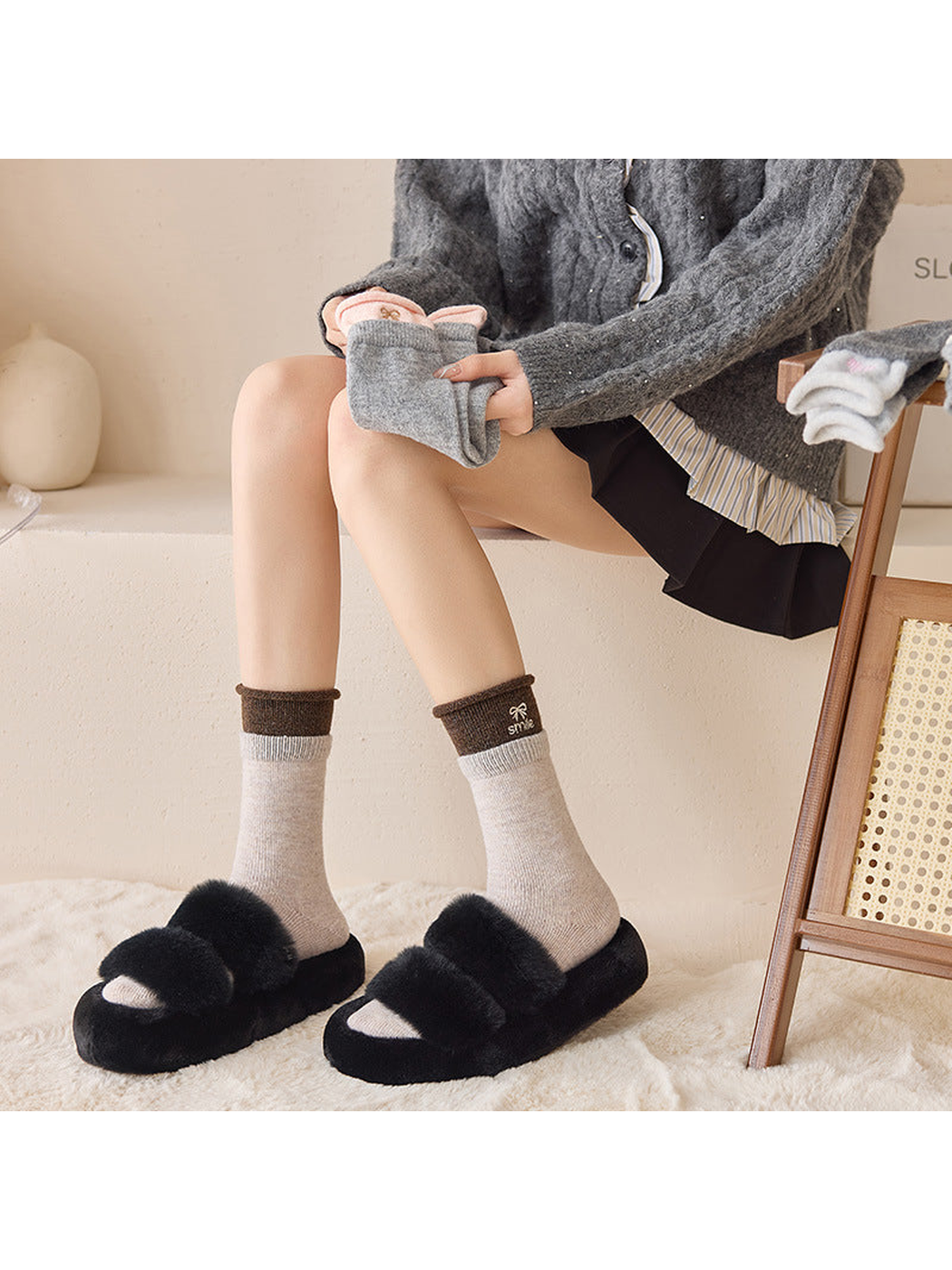Beige contrast-cuff crew socks worn with black slippers