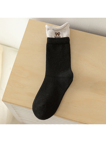 Black crew sock with beige contrast cuff and embroidered bow