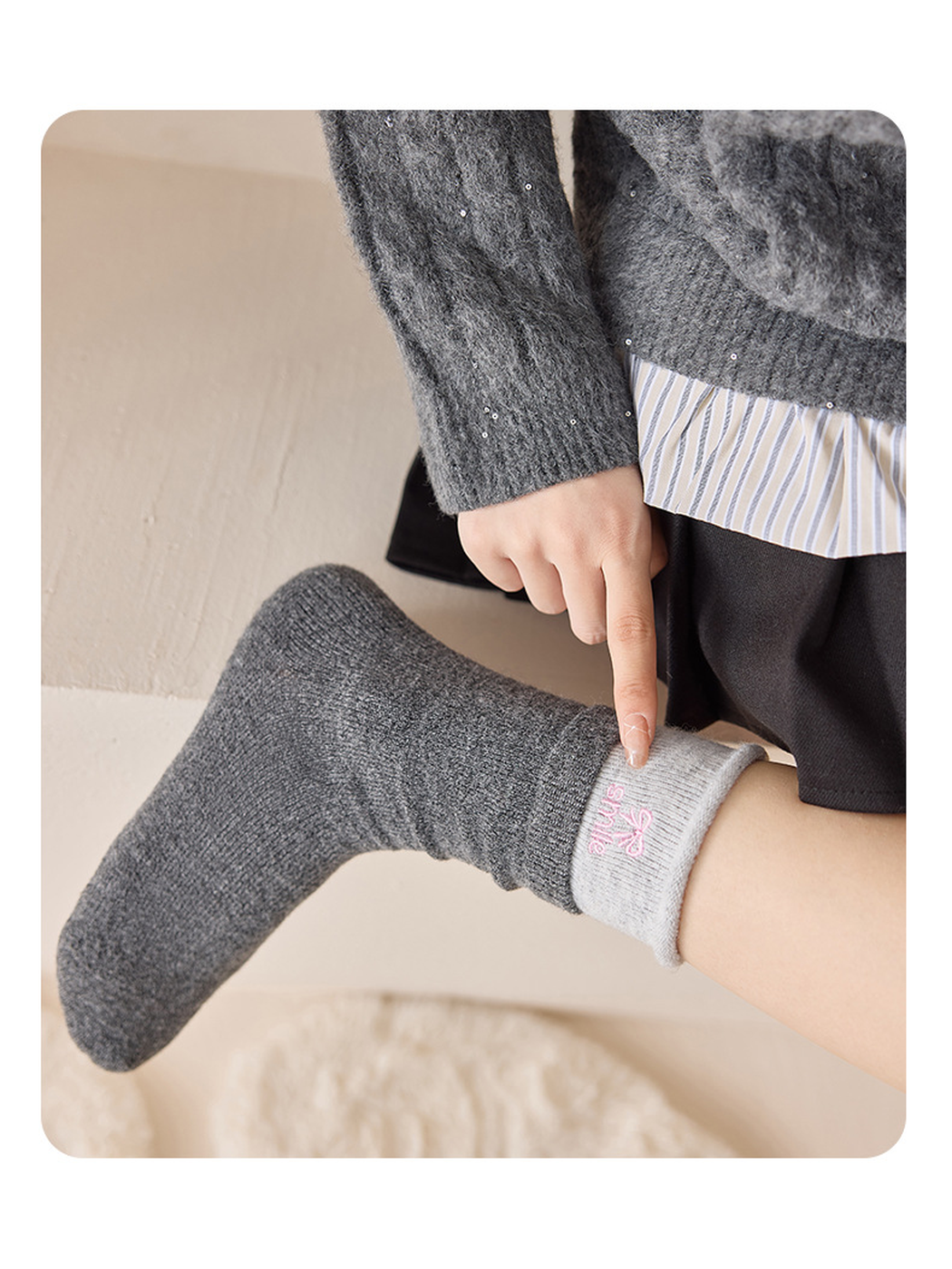 Close-up of a Dark Gray crew sock with rolled contrast cuff and embroidery