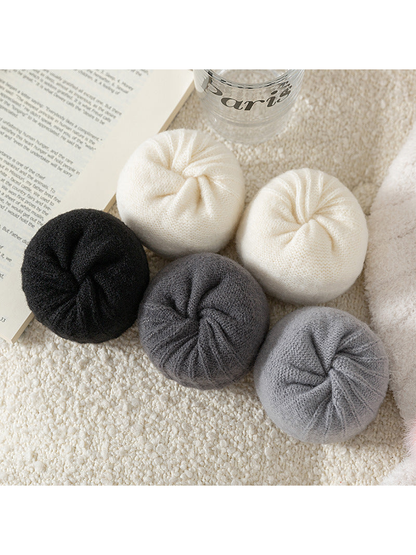 Rolled black, ivory and gray socks showing the knit texture