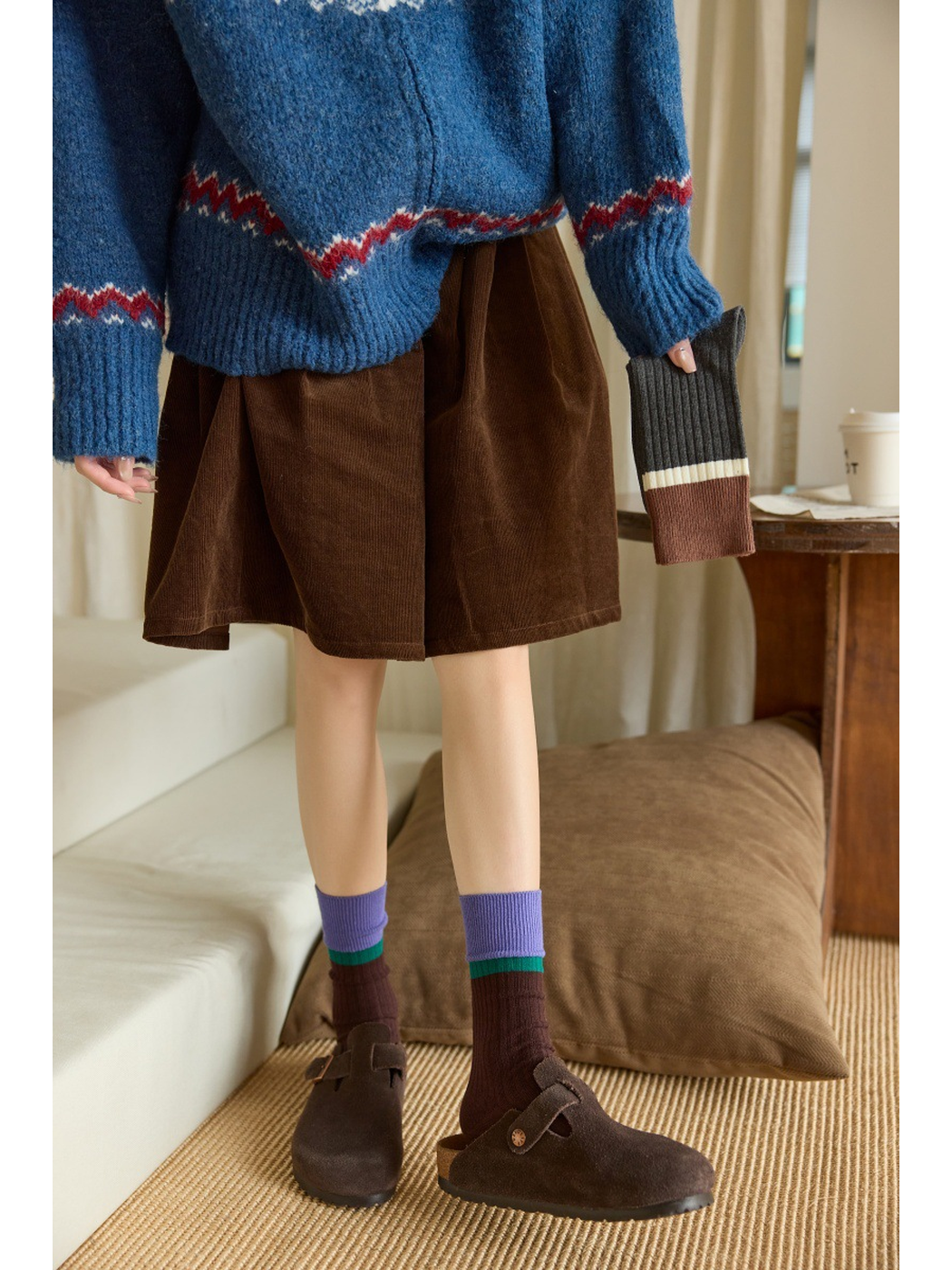 Coffee ribbed crew socks worn with clogs in an indoor setting