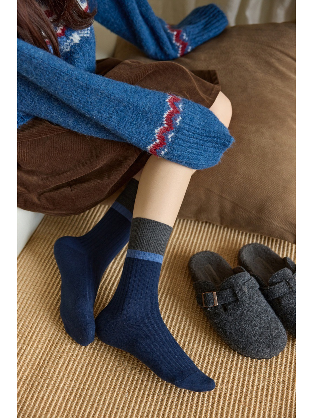 Navy ribbed crew socks worn without shoes, showing the contrasting cuff stripe