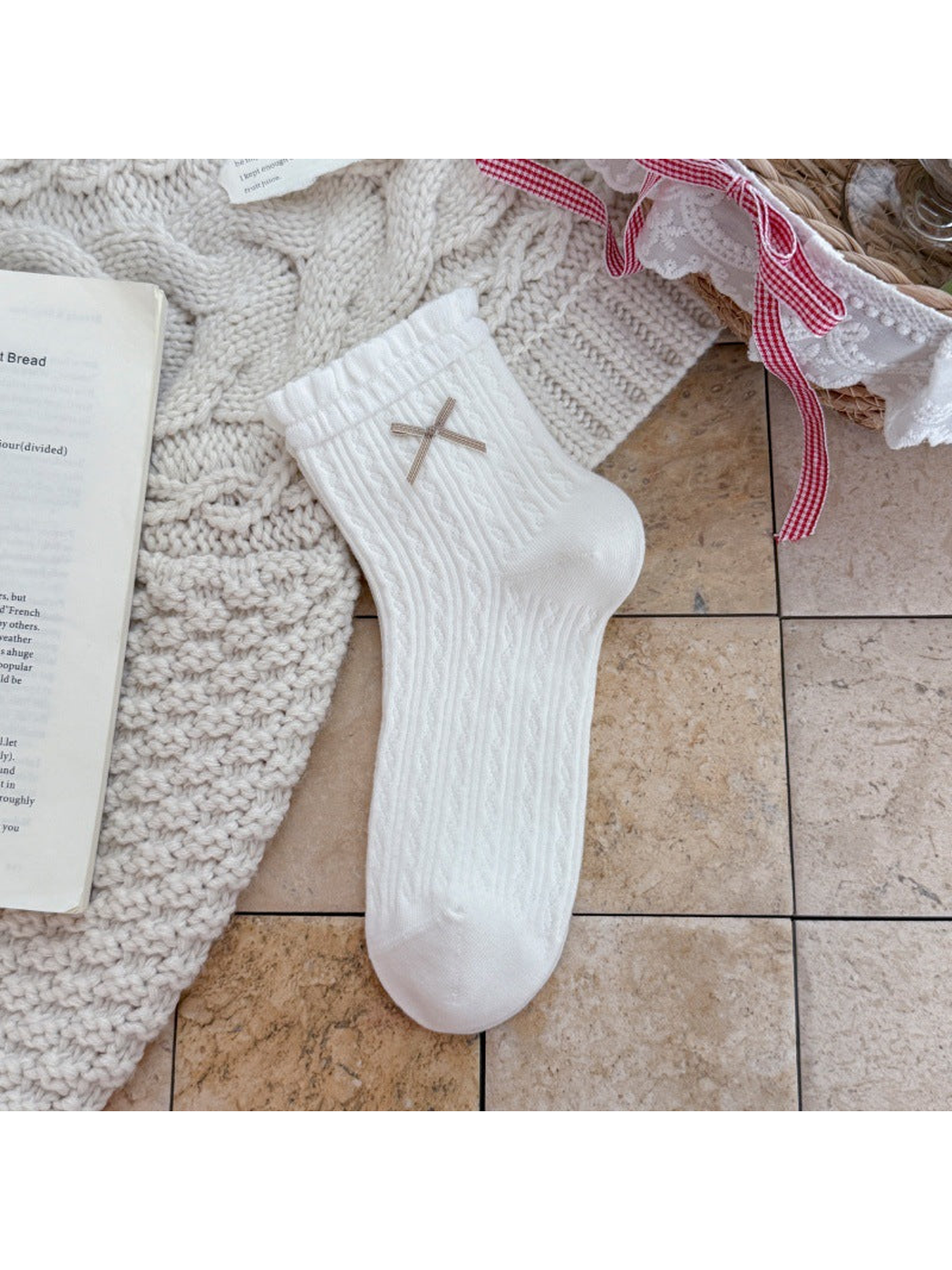 White ankle sock with ruffled cuff, ribbon bow, and pointelle texture