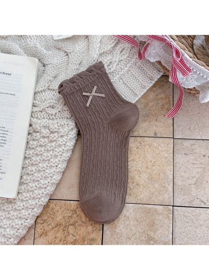 Brown ankle sock with ruffled cuff, ribbon bow, and pointelle texture