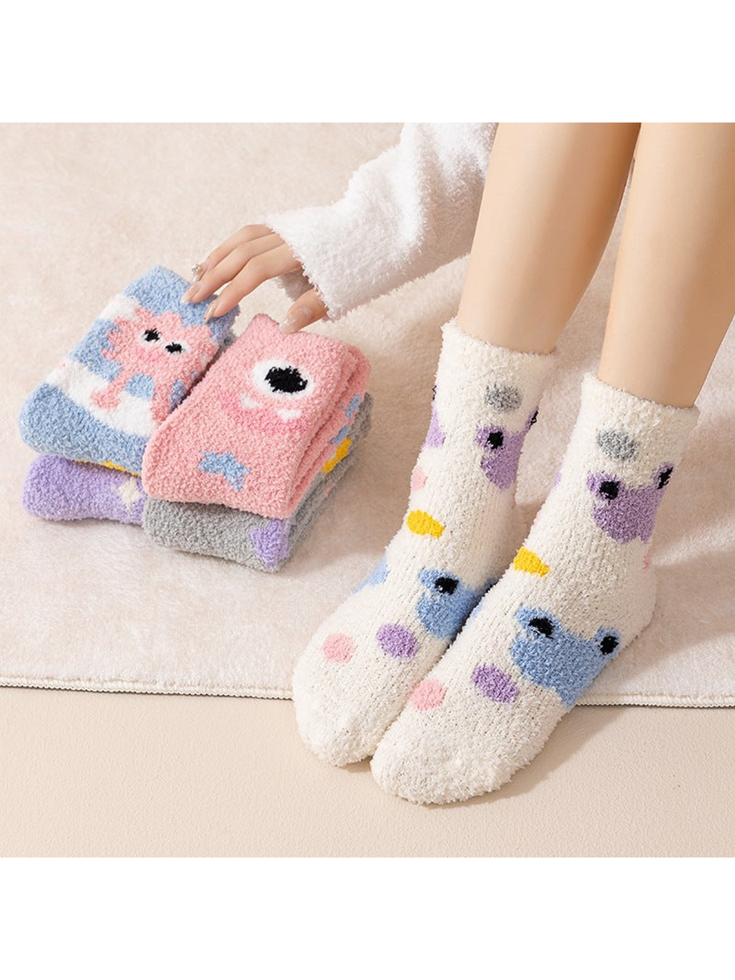 Ivory cartoon-motif crew socks worn with additional colorful styles folded nearby