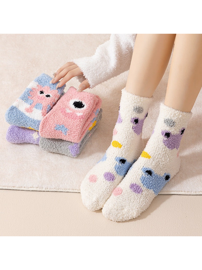 Ivory cartoon-motif crew socks worn with additional colorful styles folded nearby
