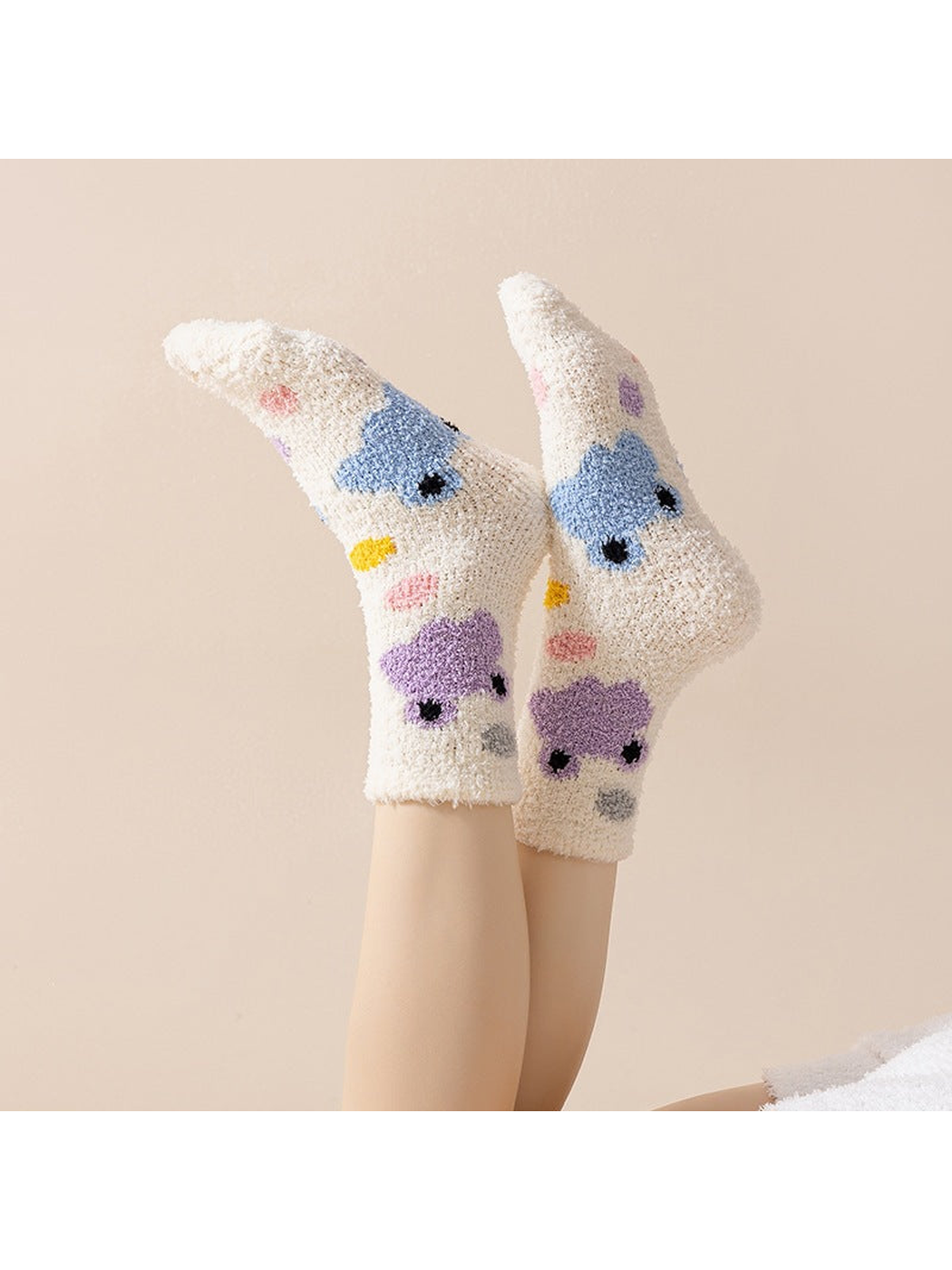 Ivory cartoon-motif crew socks worn with crossed feet