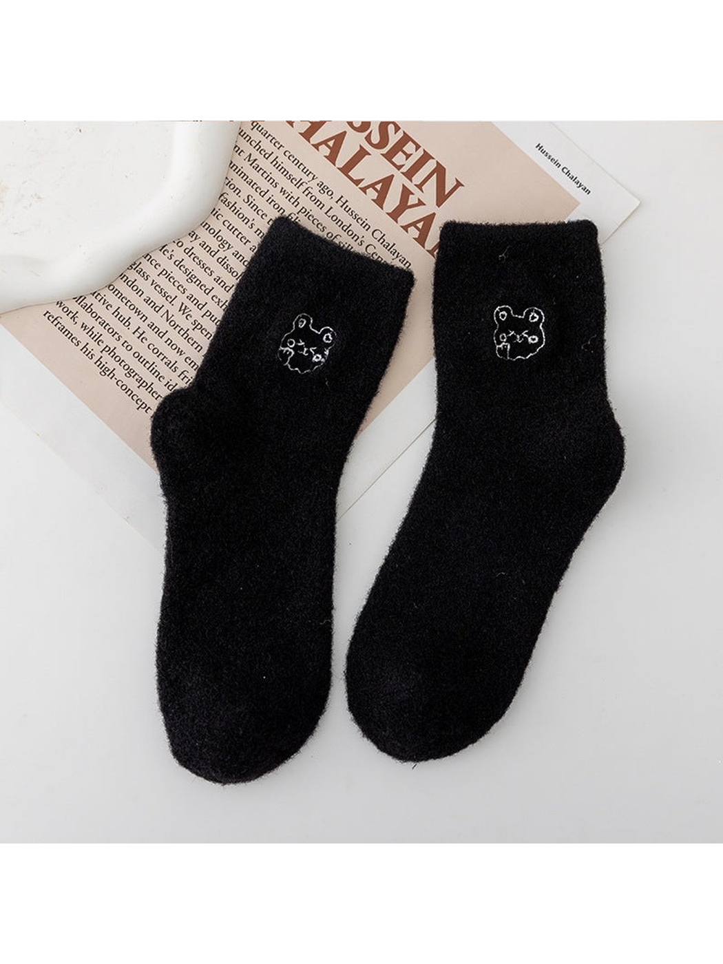 Black fuzzy crew socks with small outlined animal-face motifs