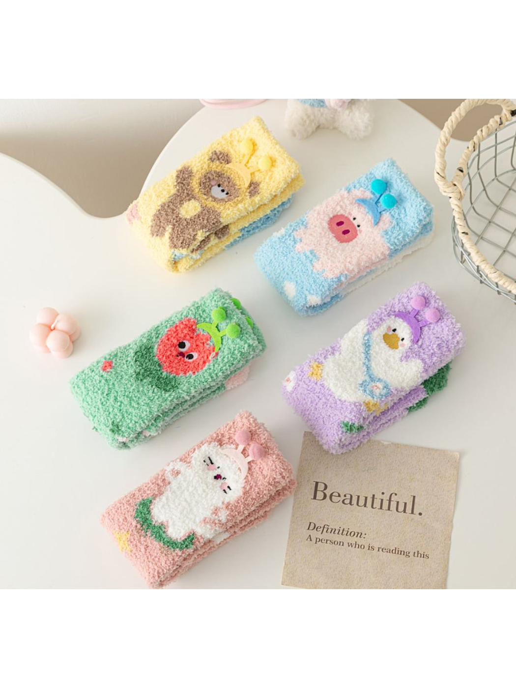 Five fuzzy character sock styles displayed folded on a tabletop