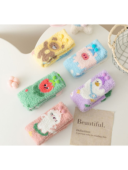 Five fuzzy character sock styles displayed folded on a tabletop