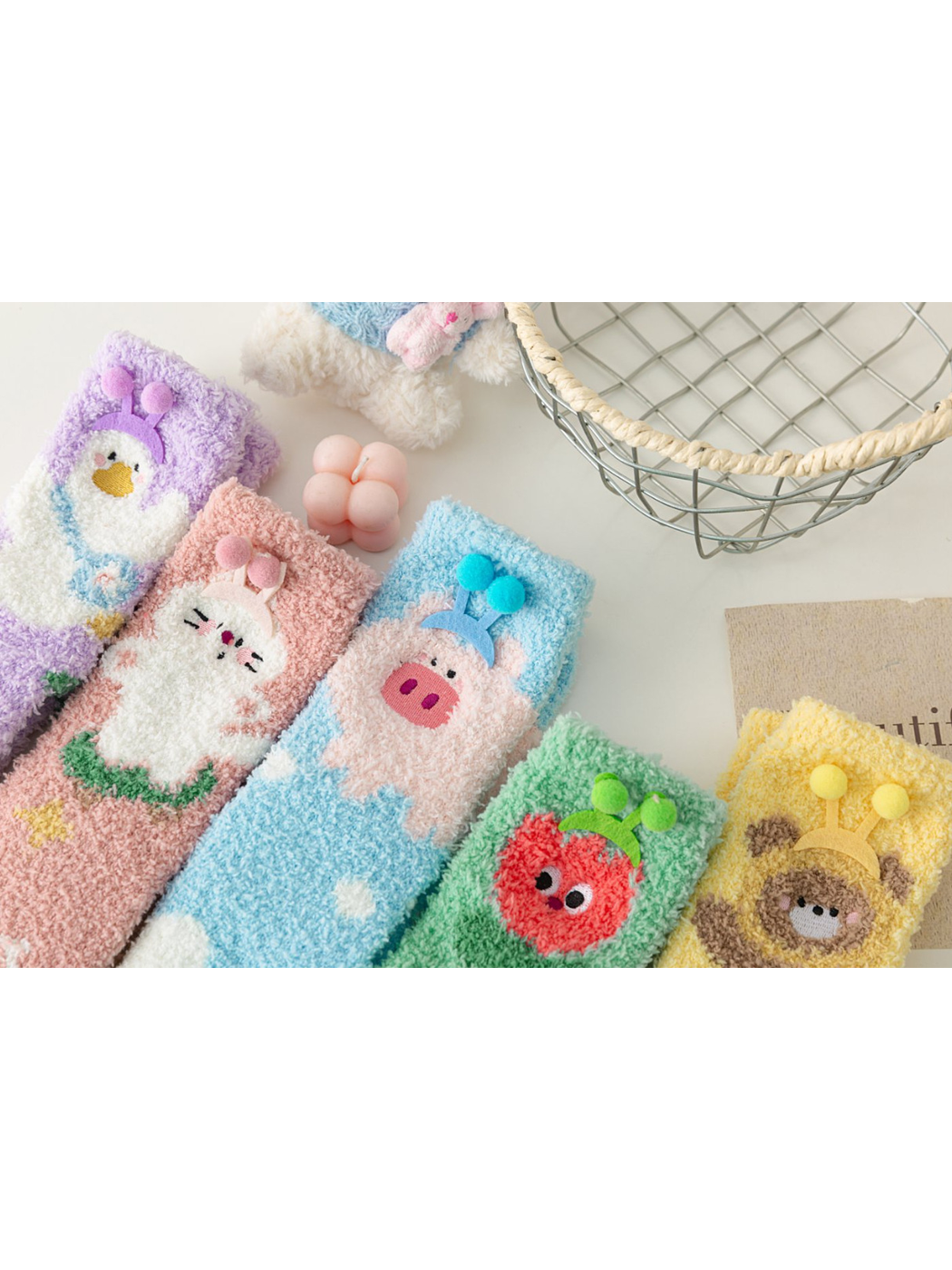 Close-up of five fuzzy character sock styles with raised pom-pom accents