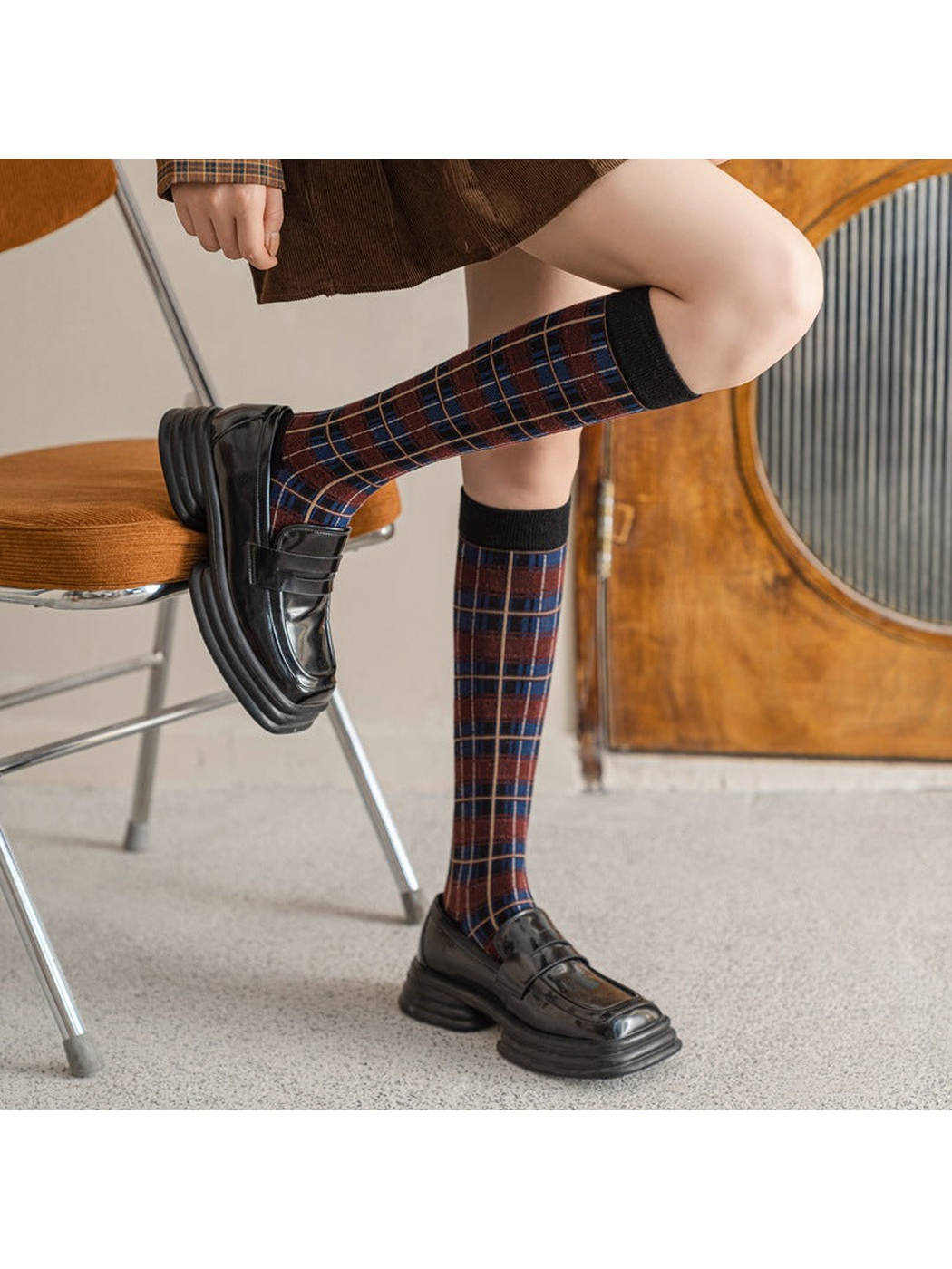 Burgundy plaid knee-high socks styled with black loafers