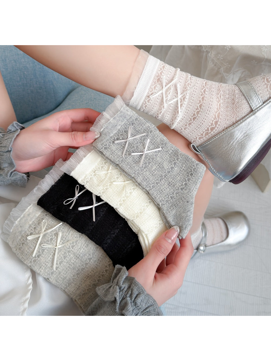 Black, white, cream, greige and light gray openwork socks with ribbon bows displayed together