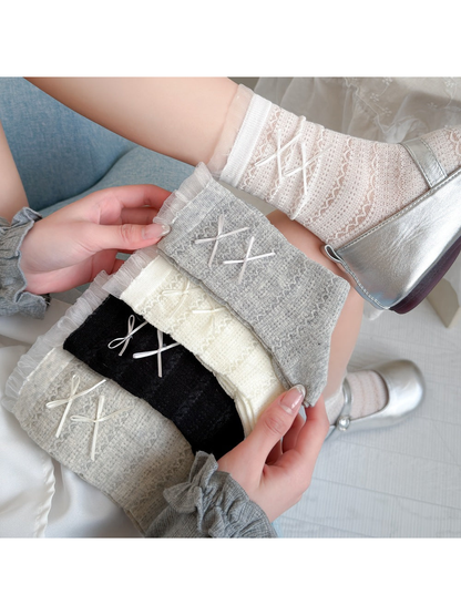 Black, white, cream, greige and light gray openwork socks with ribbon bows displayed together