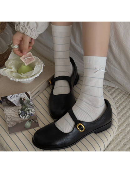 Striped Bow style white crew socks worn with black Mary Jane shoes