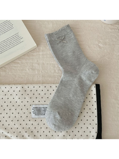 Bow style gray crew sock with ribbed texture, laid flat