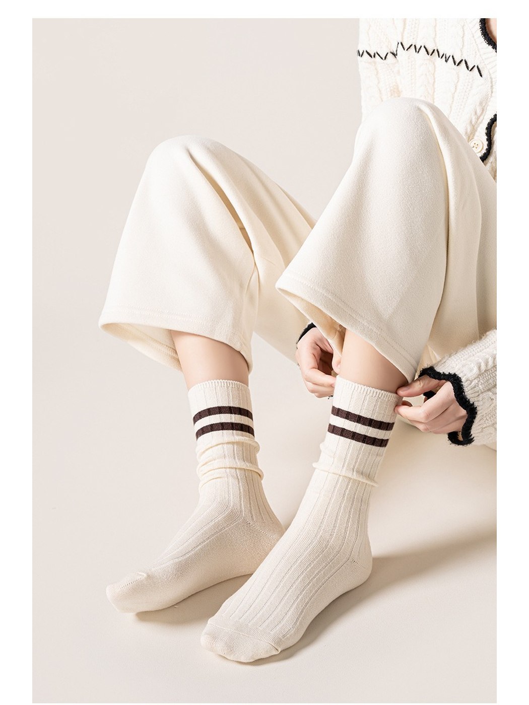Ivory striped ribbed crew socks worn while seated