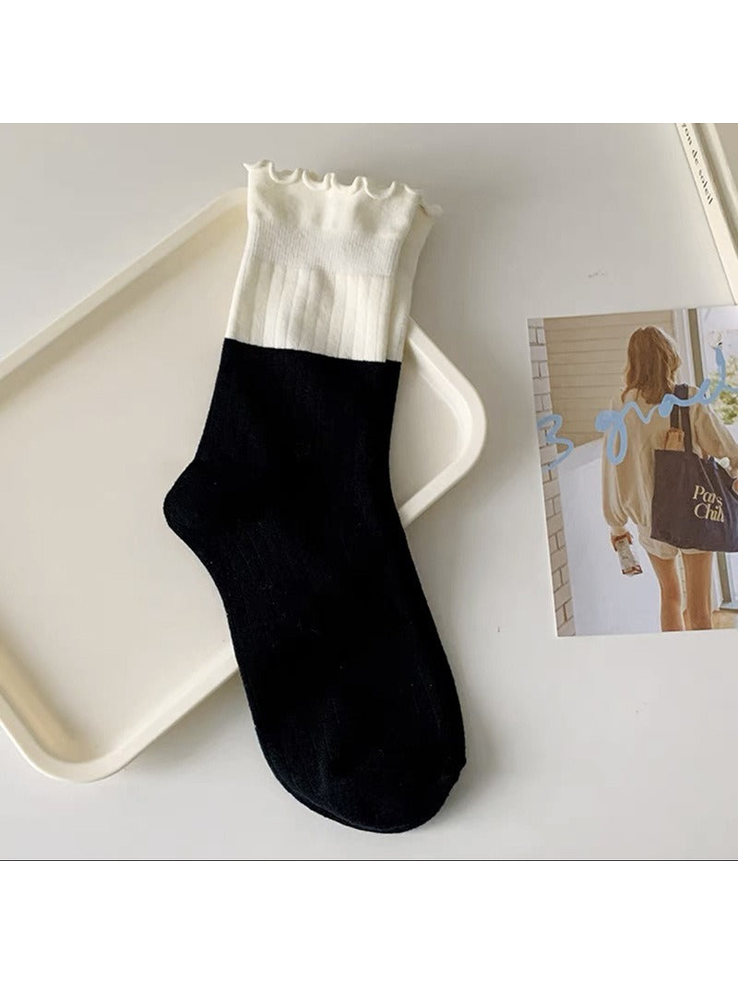 Black and white two-tone ribbed crew sock with a ruffled cuff