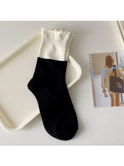 Black and white two-tone ribbed crew sock with a ruffled cuff