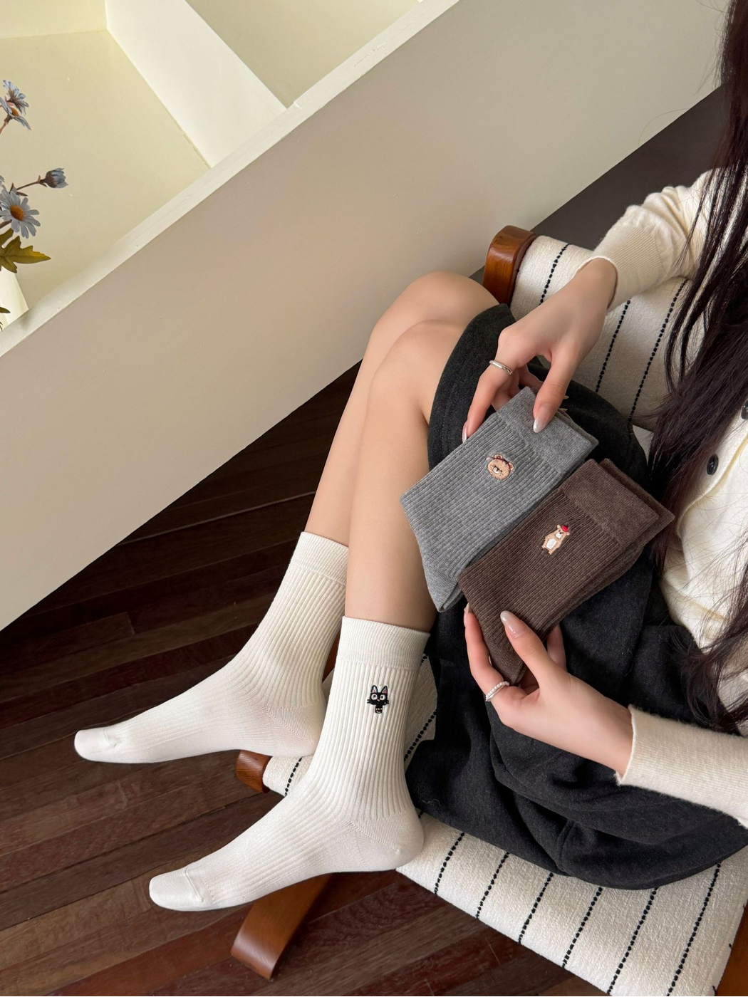 Ivory embroidered cat crew socks worn while gray and Dark Coffee styles are held