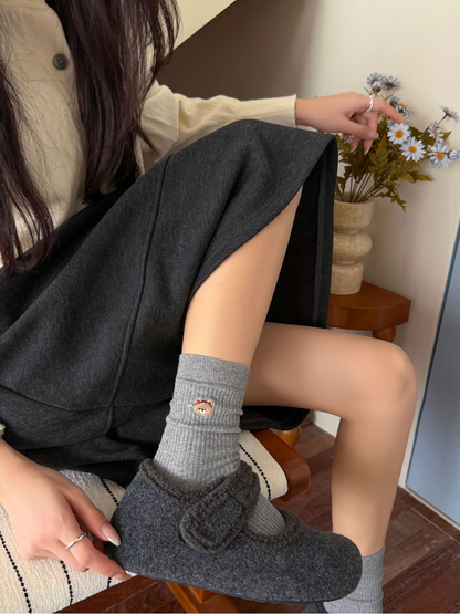 Light Gray ribbed crew socks with an embroidered bear face motif worn with gray shoes