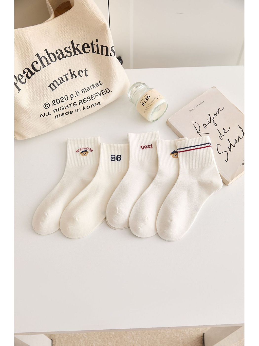 Ivory crew socks with assorted cuff motifs arranged on a tabletop