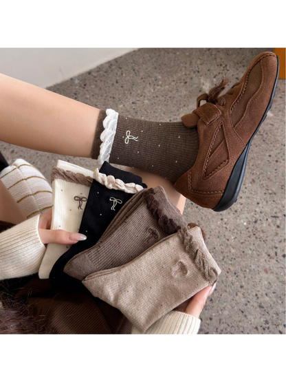 Multiple sock colors displayed together with dotted bow and ruffled cuff details