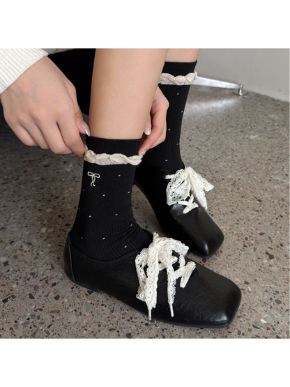 Black dotted socks with contrast ruffled cuffs styled with black shoes