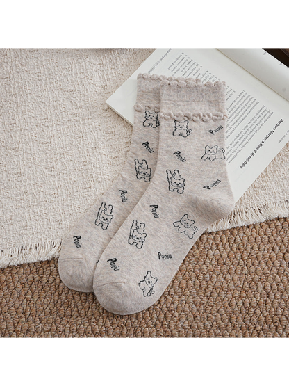Beige crew socks with cartoon dog pattern and ruffled cuffs
