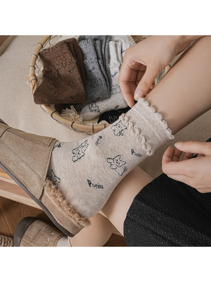 Close-up of a beige cartoon dog sock with ruffled cuff